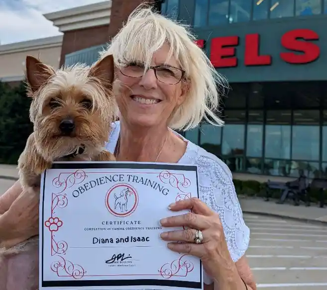 Dianna holding Isaac and their obedience training certificate